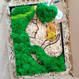 Portret kobiety z zieloną fryzurą z mchu i ogniem w dłoniach.