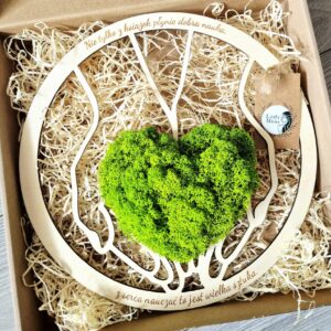 Dekoracja z zielonym sercem z chrobotka ułożonym na dłoniach i cytatem dla nauczyciela na zakończenie roku szkolnego.