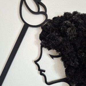 Zbliżenie na ręcznie wykonaną dekorację ścienną przedstawiającą twarz znaku zodiaku Skorpion, z wyraźnie widocznymi skorpionimi szczypcami na głowie, włosy wykonane z chrobotka reniferowego w czarnym kolorze.