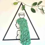 Dekoracja ścienna z chrobotkiem reniferowym. Wymiary 45 cm. Rama dekoracji w kolorze czarnych i w kształcie trójkąta. Dekoracja przedstawia znak zodiaku wodnik - profil kobiety z turkusowymi włosami z chrobotka reniferowego.