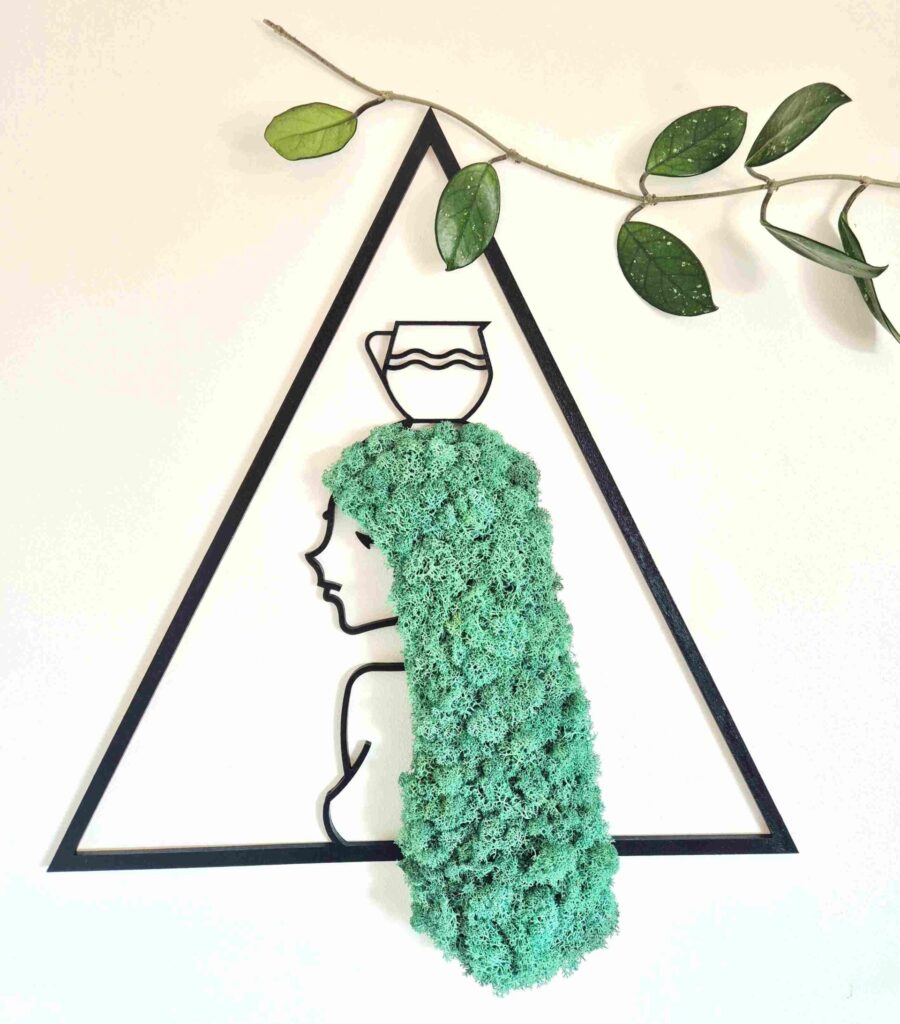 Dekoracja ścienna z chrobotkiem reniferowym. Wymiary 45 cm. Rama dekoracji w kolorze czarnych i w kształcie trójkąta. Dekoracja przedstawia znak zodiaku wodnik - profil kobiety z turkusowymi włosami z chrobotka reniferowego.