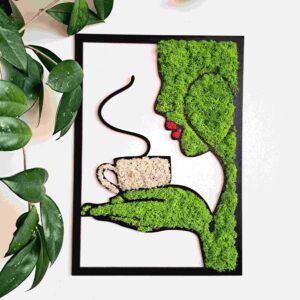 Nowoczesna ręcznie wykonana dekoracja ścienna z naturalnego chrobotka reniferowego w jasnozielonym kolorze. Obraz przedstawia kształt kobiecej sylwetki trzymającej na dłoniach filiżankę z chrobotka reniferowego w kolorze beżowym.