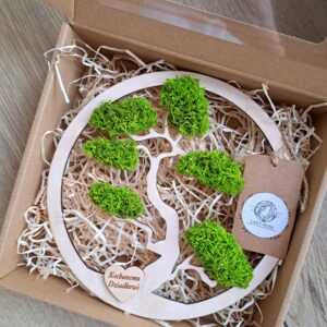 Drzewko Kochanemu Dziadkowi z chrobotkiem reniferowym i serduszkiem z napisem Kochanemu Dziadkowi. Na obrazku widoczne jest dekoracyjne drzewko o wysokości 20 cm wykonane z naturalnego chrobotka reniferowego. Na dole drzewka znajduje się drewniane serduszko z wygrawerowanym napisem „Kochanemu Dziadkowi”, które nadaje całości osobisty i wzruszający charakter. Drzewko umieszczono na stabilnej podstawie, a całość zapakowano w estetyczne tekturowe pudełko z okienkiem, dzięki czemu produkt jest gotowy do wręczenia jako prezent z okazji Dnia Dziadka.